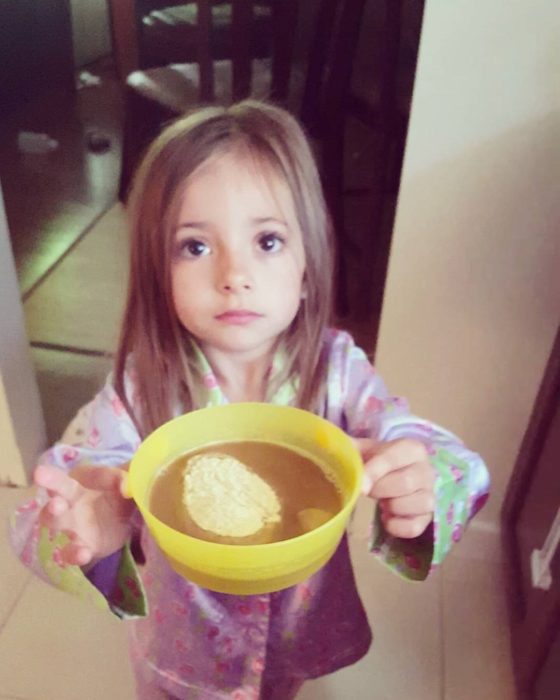 niña sosteniendo un tazón con café