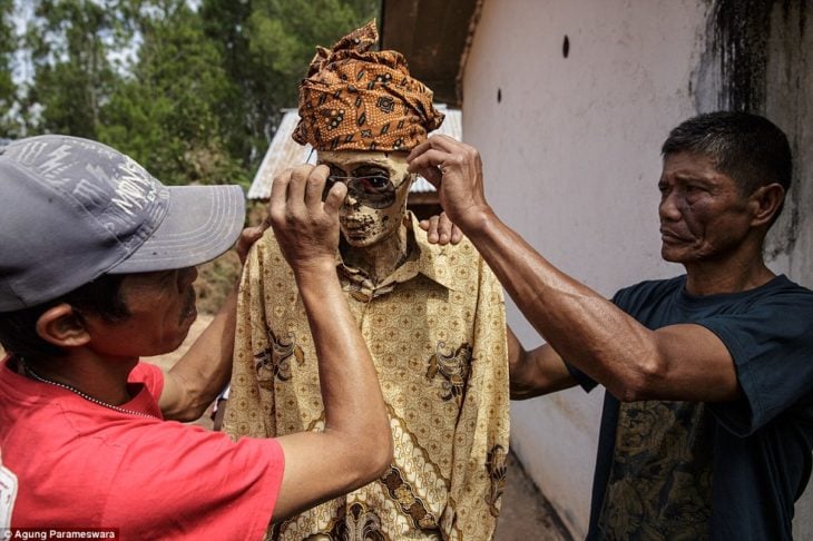 dos hombres poniendo lentes a un cadáver