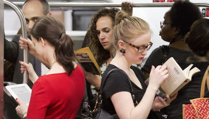 personas leyendo en el metro