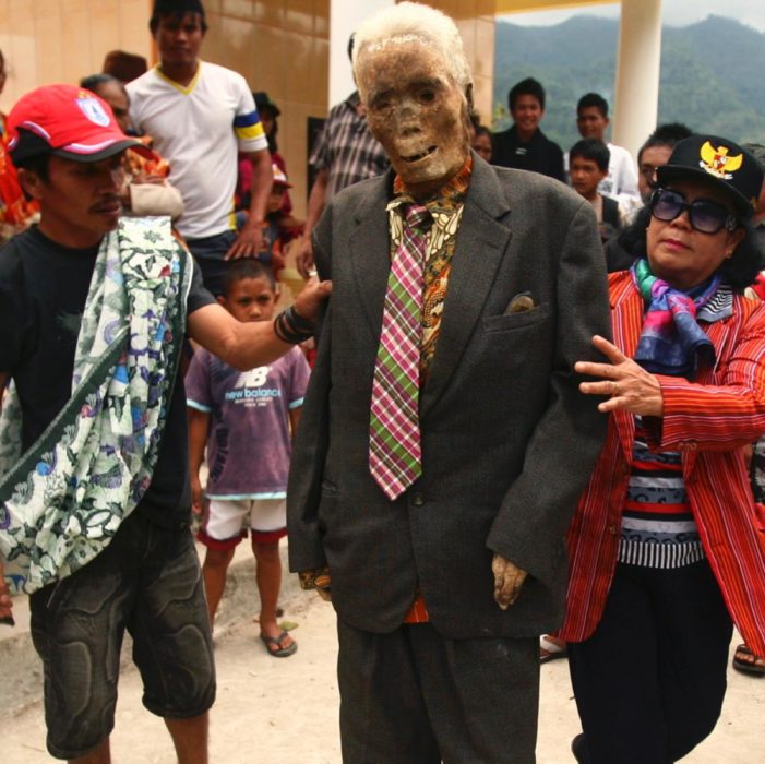 personas sosteniendo un cadáver 