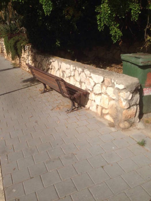 banca frente a un muro de piedra