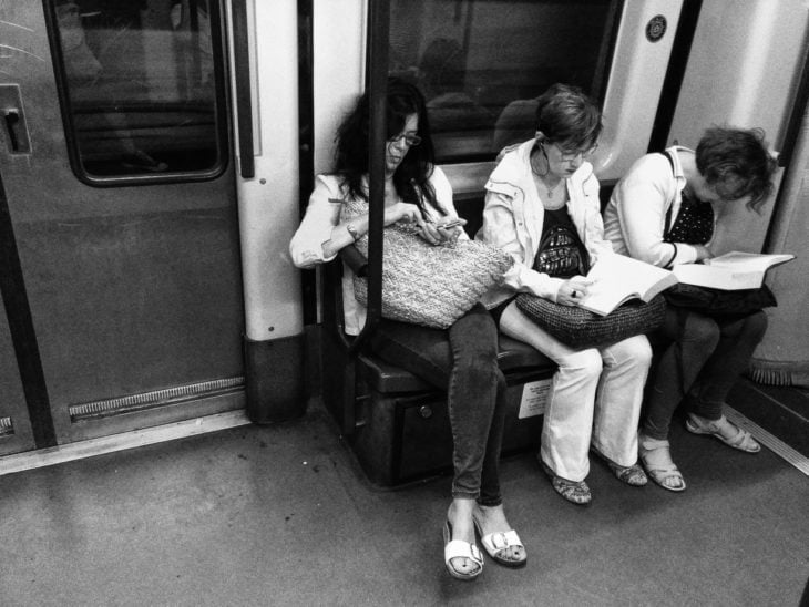 foto a blanco y negro personas leyendo en el metro