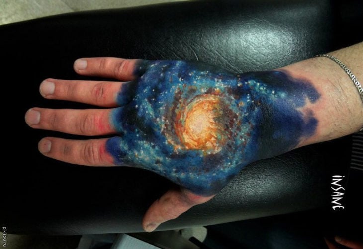 tatuaje del universo en una mano