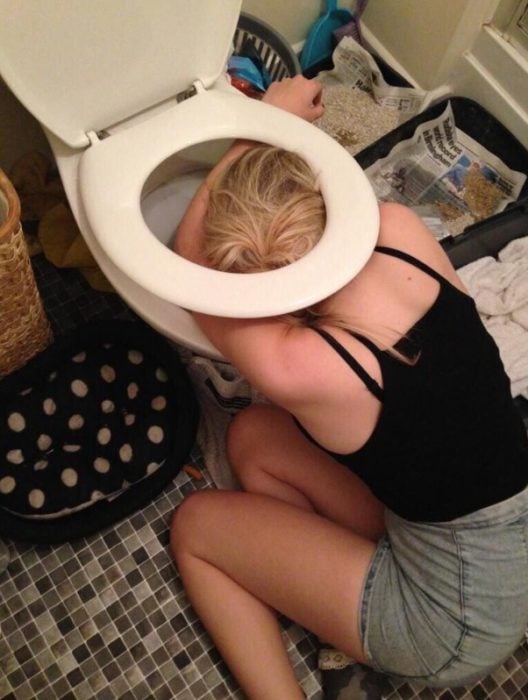 Foto de chica en shorts vomitando después de una borrachera