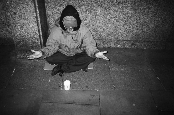 vagabundo meditando dsobre el asfalto frío de Londres