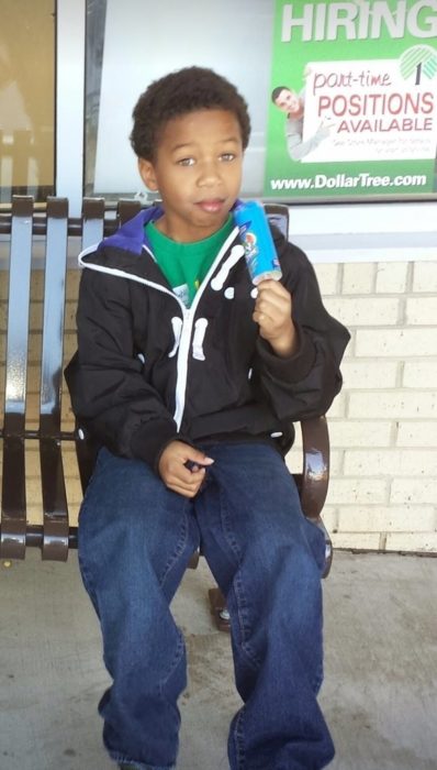 Niño dona su cabello - comiendo nieve con su cabello corto