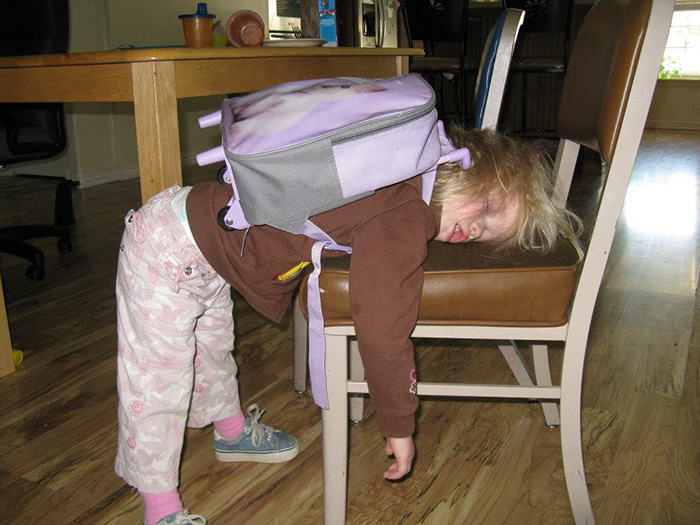 Niña con su mochila se queda dormida de pie 