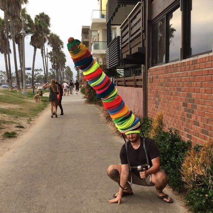 hombre con un montón de gorros en la cabeza