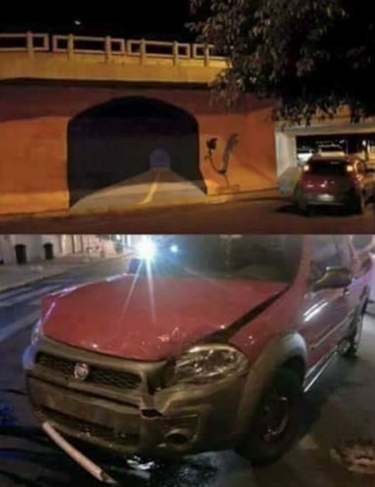 Grafiti en un muro de un puente. Al lado un carro chocado