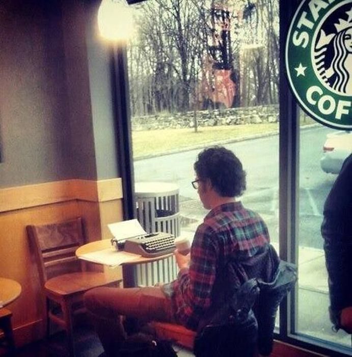 Hombre en cafetería con su máquina de escribir