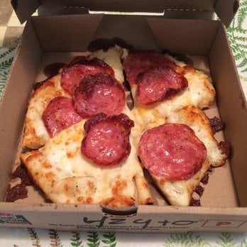 Pizza de cuatro pedazos, sin ninguna forma, con 7 trozos grandes de salami y quemada de las orillas