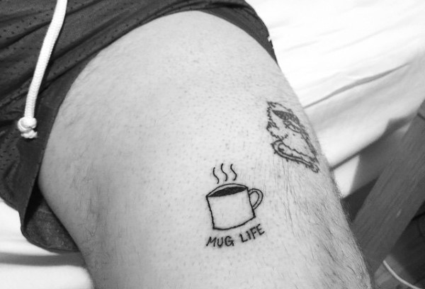 Tatuaje de una taza de café y dice mug life