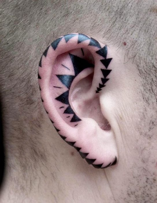 Tatuaje de triángulos en el oído