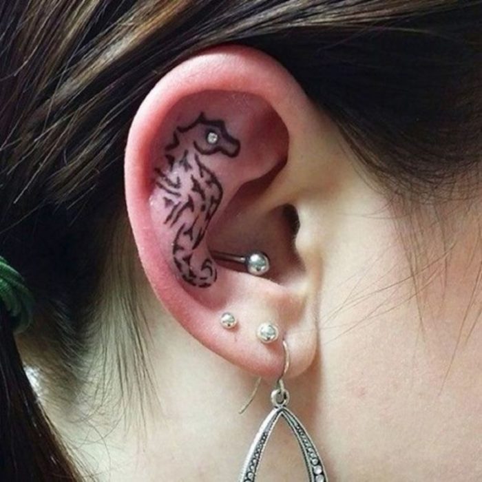 Tatuaje de un caballo de mar adentro del oído