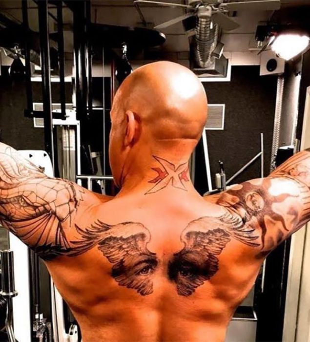 Vin Diesel ejercitándose. Se ve un tatuaje de unas alas y una mirada en su espalda