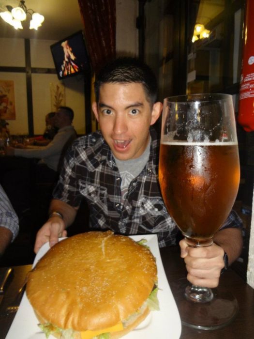 chico con hamburguesa y cerveza gigante