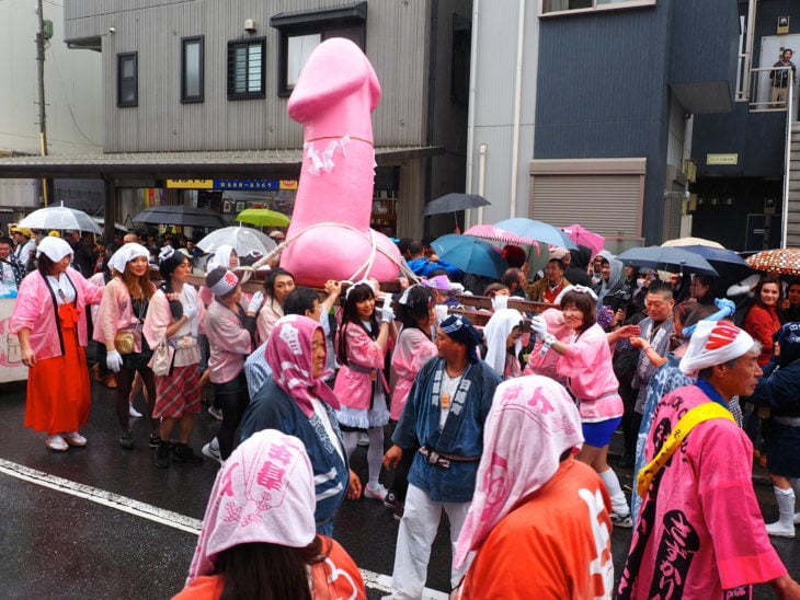 japoneses cargando una escultura gigante de pene