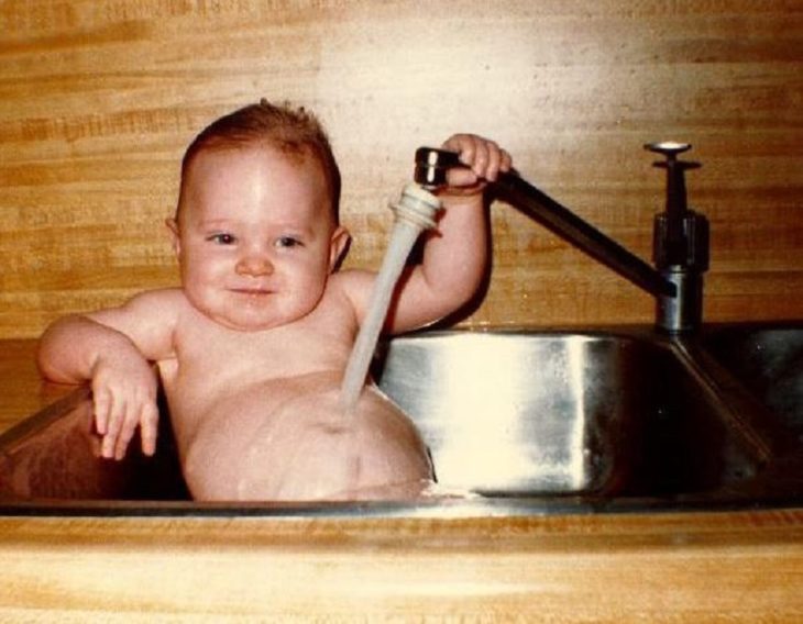 bebé bañándose en un lavaplatos