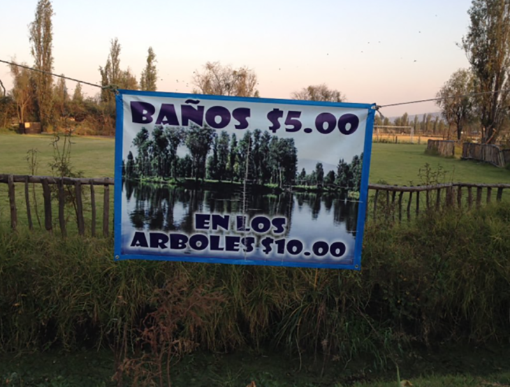 cartel de baños en un bosque