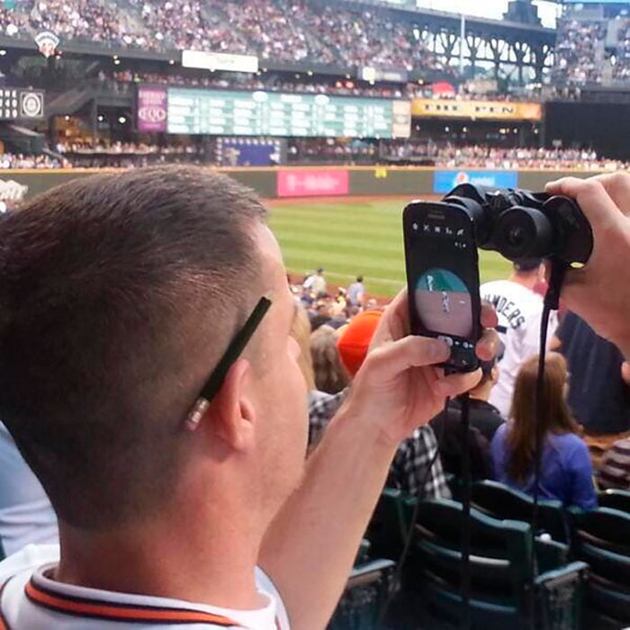 hombre con celular mirando partido deportivo