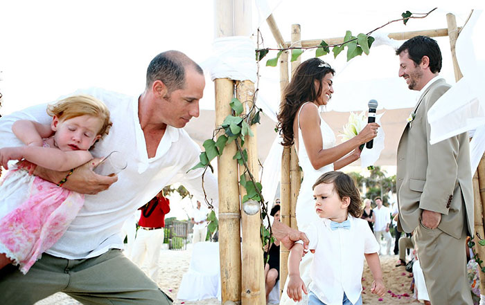 señor sosteniendo a sus hijos en boda