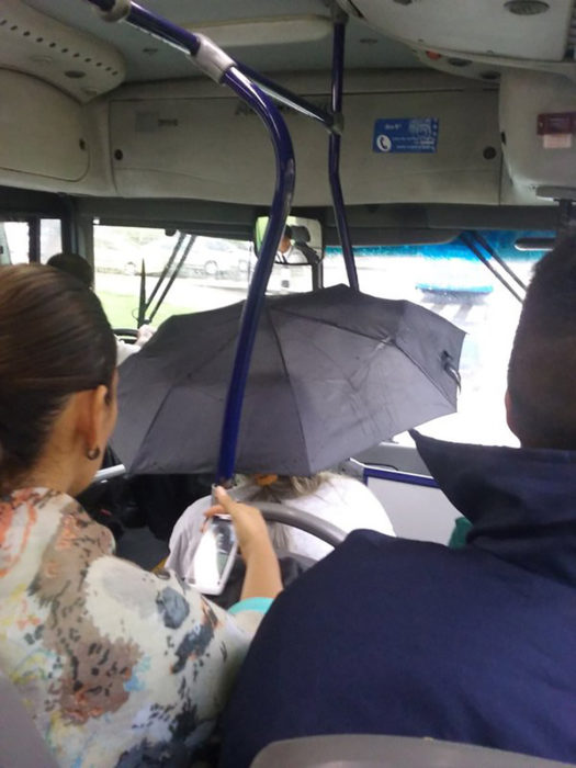 señora con paraguas dentro del autobús