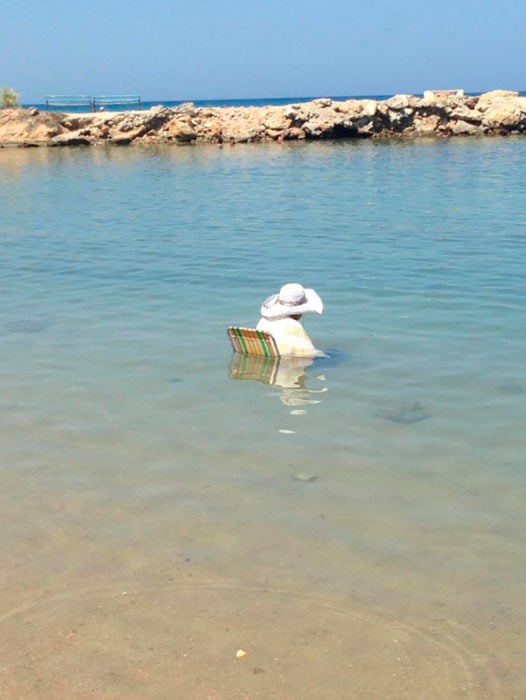 señora sentada en medio del mar