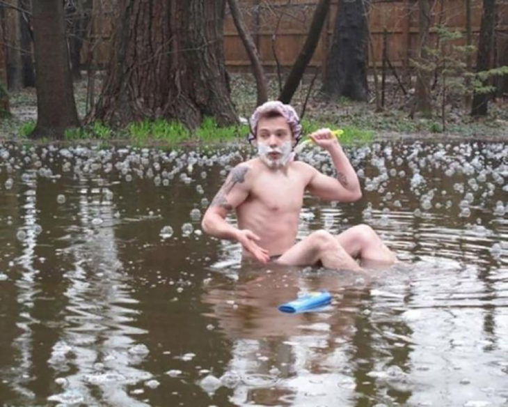 hombre bañandose en un charco de agua