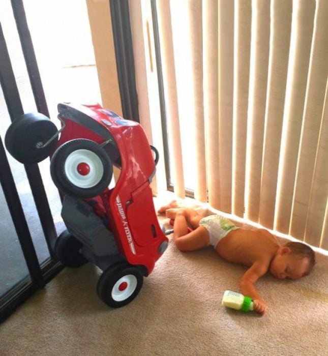 niño tirado con un carro y una teta 