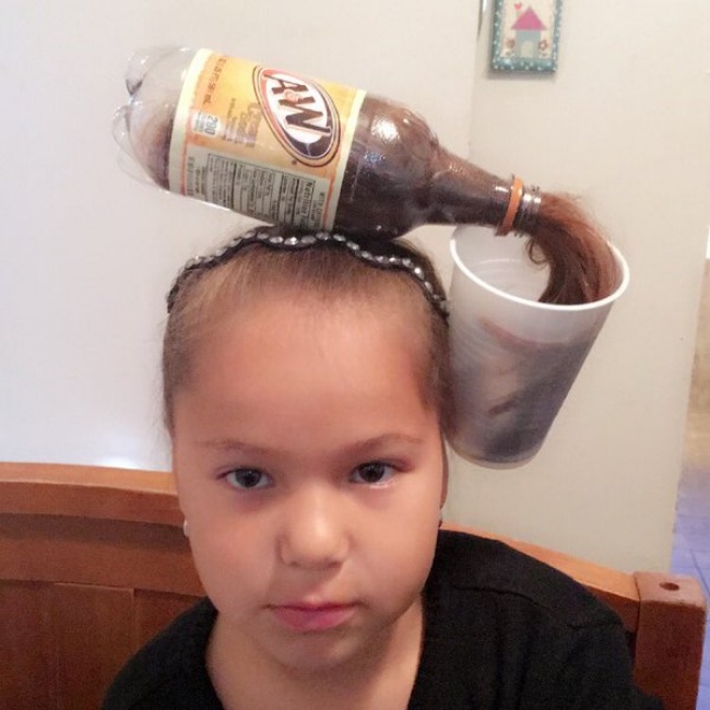 niña con una botella en la cabeza