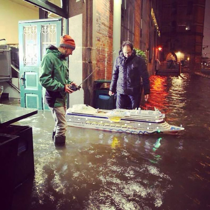 hombres con un barco de motor sobre una inundación