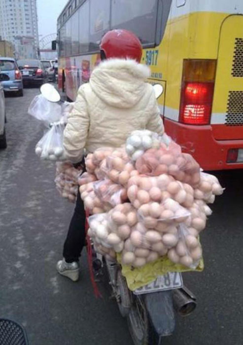 persona transporta huevos en motocicleta