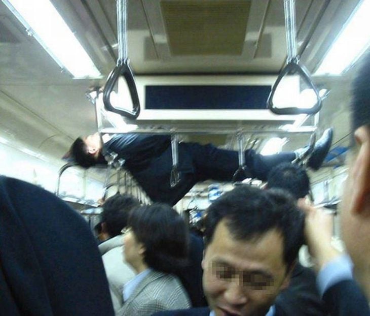 hombre dormido en pasamanos del metro