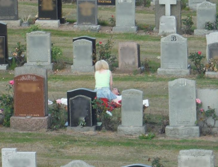 pareja acariciándose en cementerio