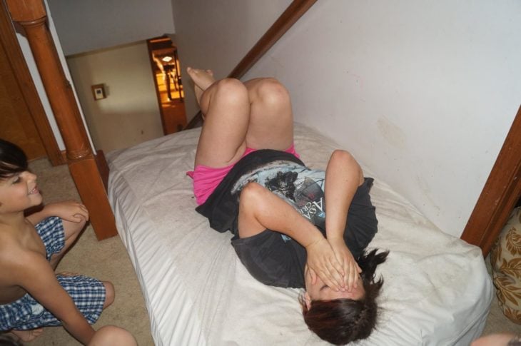 muchacha en cama tapándose la cara