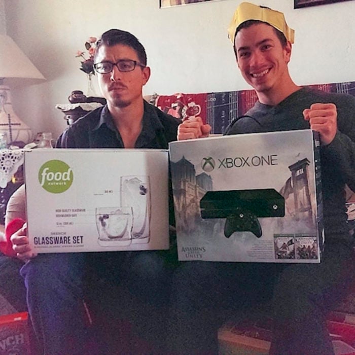 dos jóvenes sosteniendo regalos, uno es un xbox y otro un juego de vasos