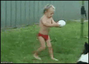 bebé trata de lanzar una pelota