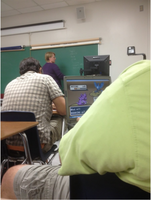 alumno jugando videojuegos dentro del salón de clase