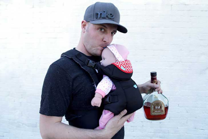 hombre cargando bebé de plástico y botella