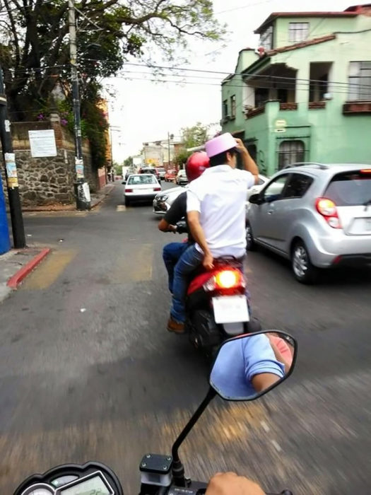 chico en moto con recipiente en la cabeza