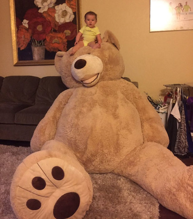 NIÑA ARRIBA DEL GRAN OSO DE PELUCHE