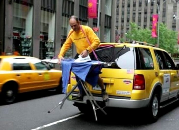 Fotos sin sentido - Hombre en la parte de atrás de un taxi planchando una camisa