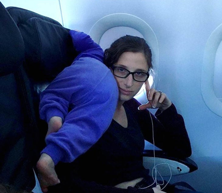 Papás cansados -bebé en el avión encima de mama