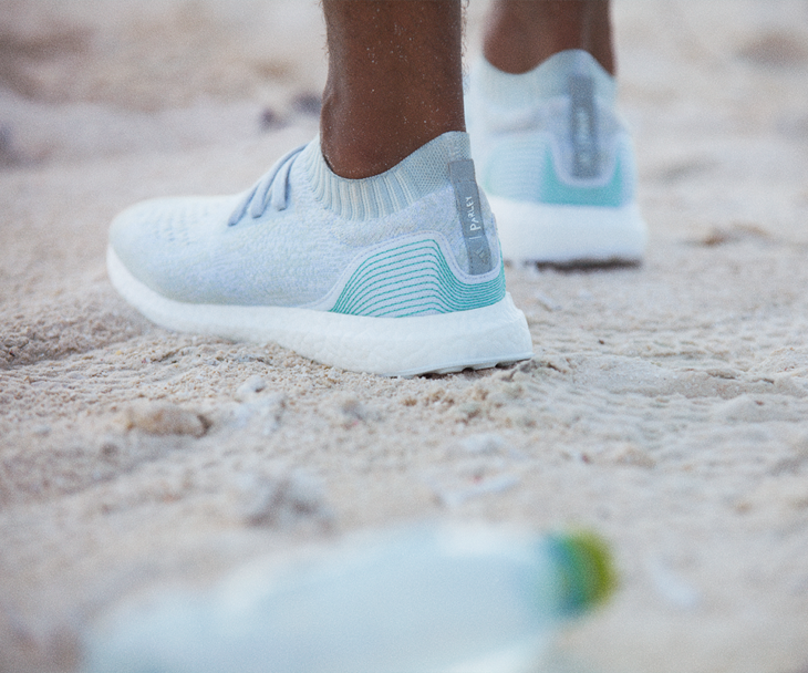 hombre usando tenis azules en arena de mar