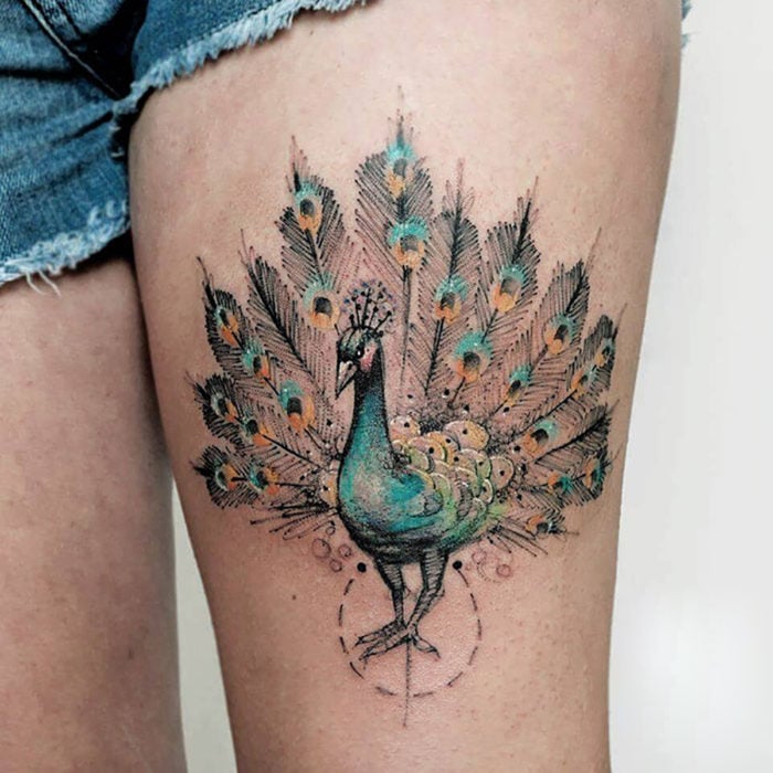 tatuaje de pavorreal en pierna de mujer