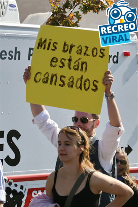 hombre sosteniendo un cartel amarillo