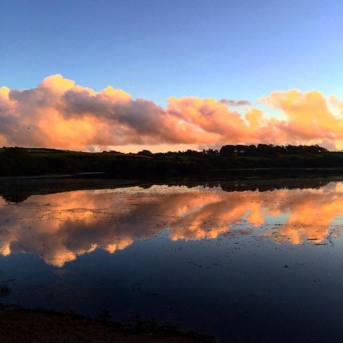 paisaje de montaña y cielo se refleja simétricamente en el agua