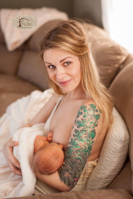 mujer con tatuaje amamantando a su hijo 