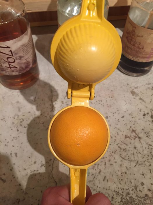 naranga dentro de un exprimidor de naranjas 