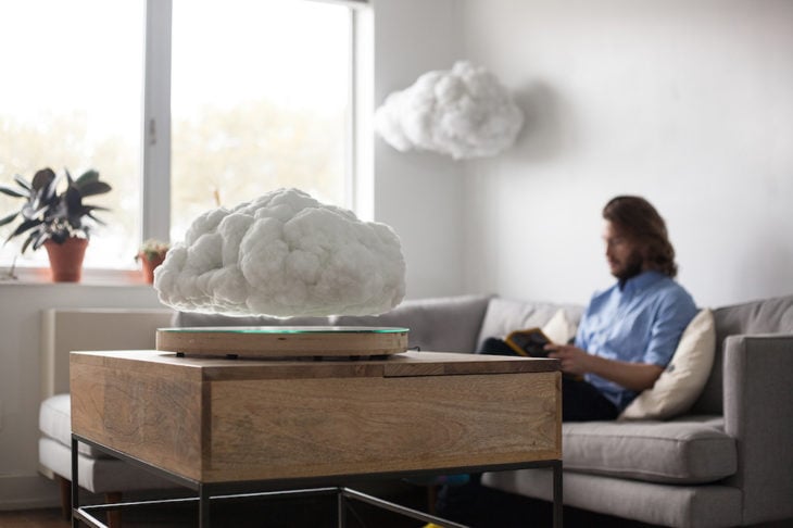 chico en un sala con una bocina levitante en forma de nube